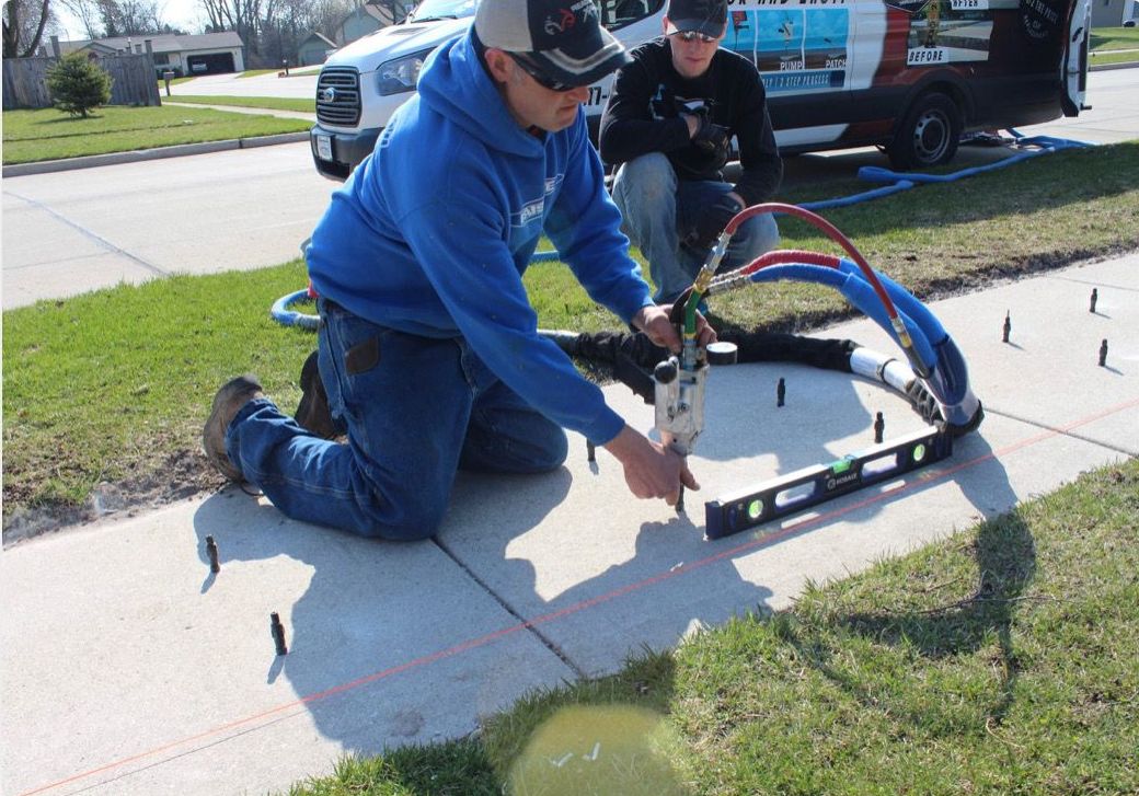 Crew leveling a sidewalk with injection equipment — Magic Raising job photo